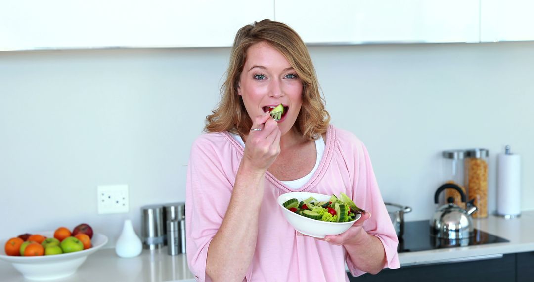 Woman Enjoying Fresh Salad in Modern Kitchen - Free Images, Stock Photos and Pictures on Pikwizard.com