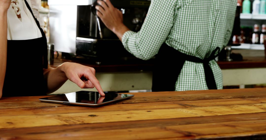Waitress Using Digital Tablet at Cafe Counter