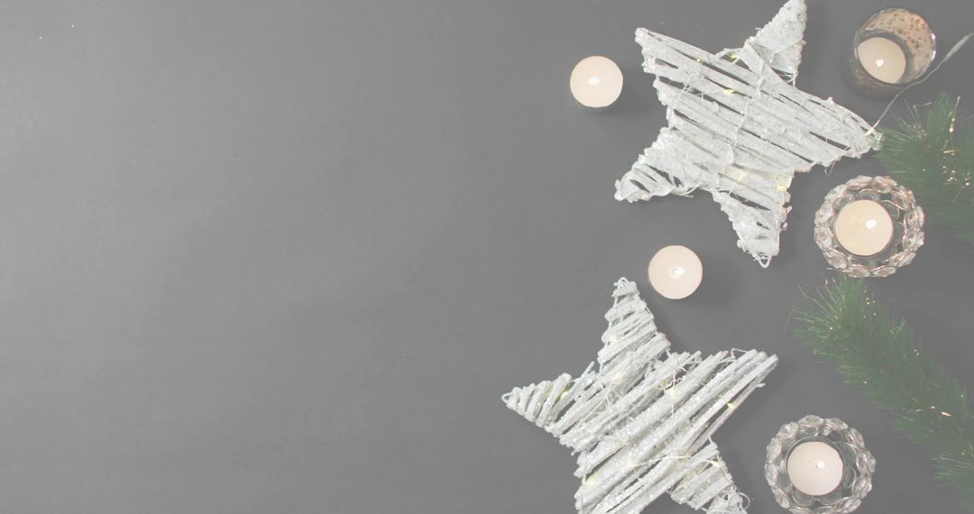 Rustic Woven Star Ornaments and Candlelight on Neutral Gray Background with Copy Space