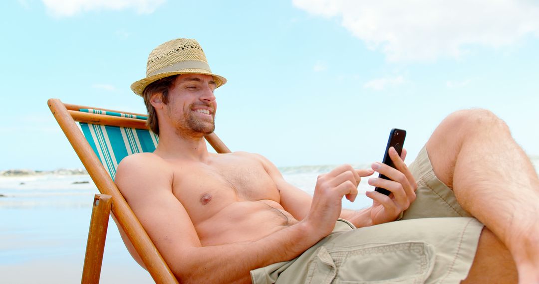 Relaxed Man Using Smartphone on Beach Deck Chair - Free Images, Stock Photos and Pictures on Pikwizard.com