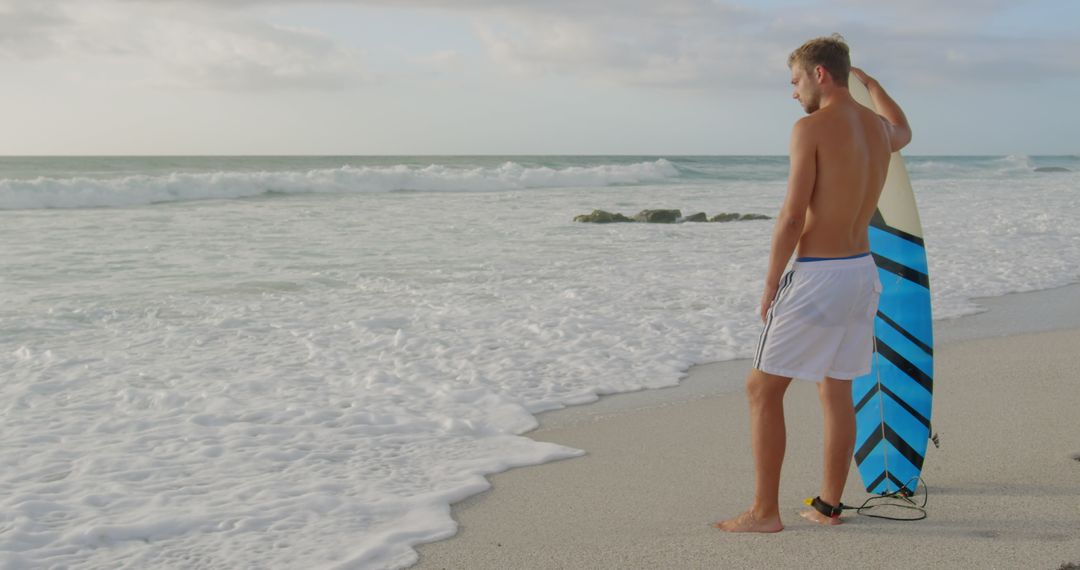Surfer Facing Ocean with Surfboard