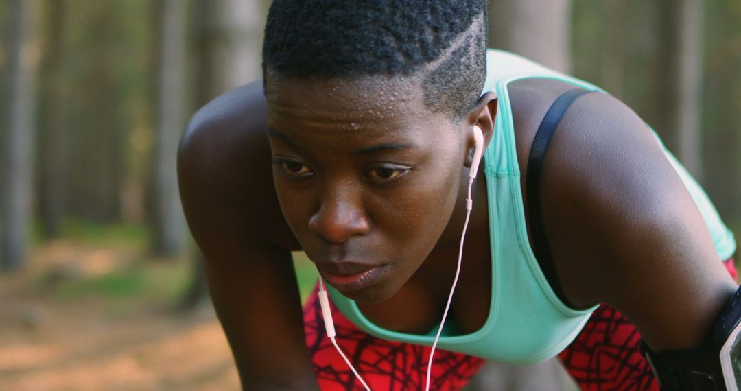 Young Athlete with Earphones Taking a Break in Forest - Free Images, Stock Photos and Pictures on Pikwizard.com