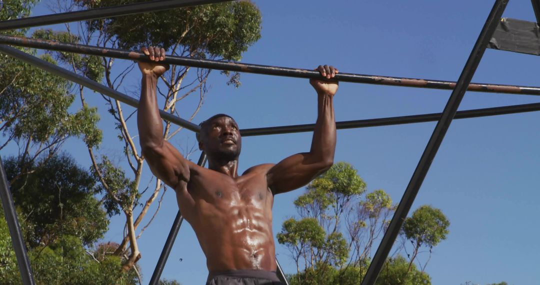 Strong Man Performing Pull-Up Under Blue Sky