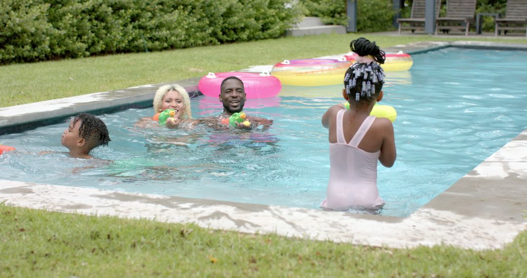 Happy Family Relaxing and Playing in Backyard Pool on Sunny Day