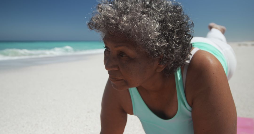 Elderly Woman Exercising on Beach in Sunny Weather - Free Images, Stock Photos and Pictures on Pikwizard.com