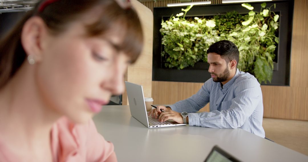 Colleagues Working on Laptops in Modern Office Environment