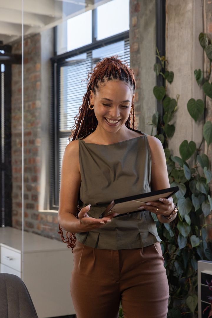 Smiling Professional Woman Engaging with Digital Tablet in Modern Office