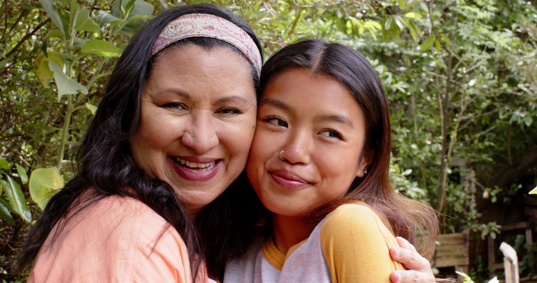 Mother and Young Daughter Embracing with Joy in Green Garden