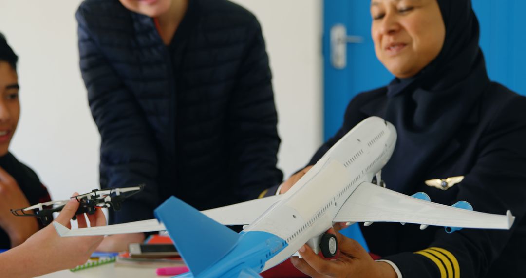 Female Teacher with Hijab Engaging Students with Model Airplane in Class - Free Images, Stock Photos and Pictures on Pikwizard.com