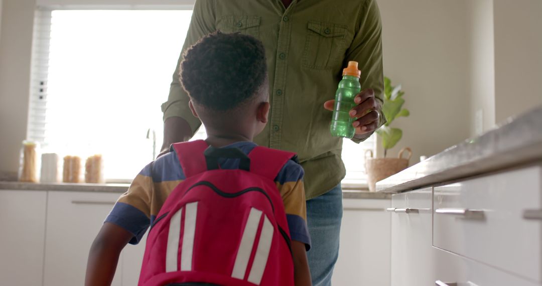 Father Preparing Child for School Holding Water Bottle - Free Images, Stock Photos and Pictures on Pikwizard.com