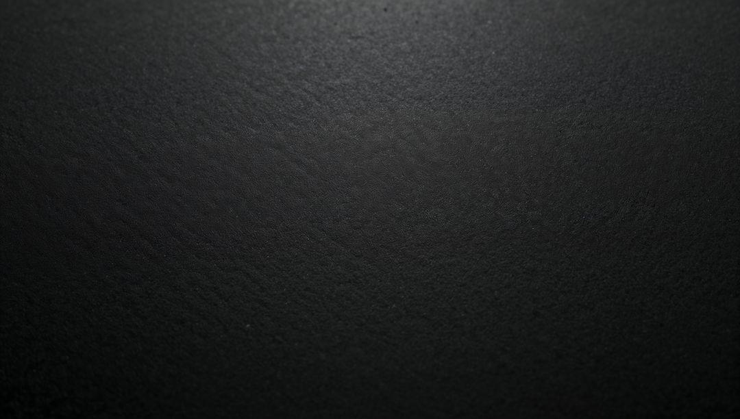 Matte Black Texture Showing Subtle Speckle and Soft Overhead Light