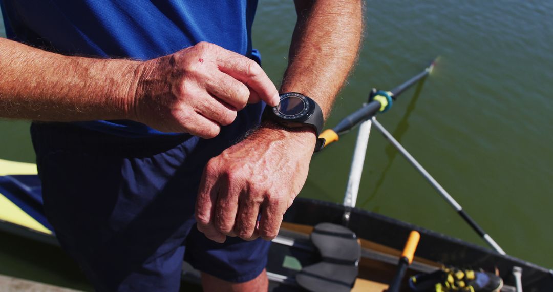 Athlete Checking Smartwatch by Rowing Boat on Water - Free Images, Stock Photos and Pictures on Pikwizard.com