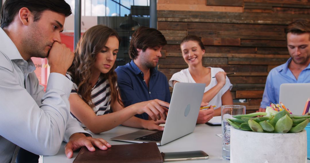 Team Collaborating in Modern Office with Laptop