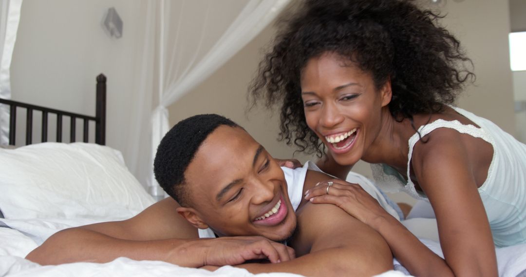 Happy African American Couple Relaxing on Bed Together - Free Images, Stock Photos and Pictures on Pikwizard.com