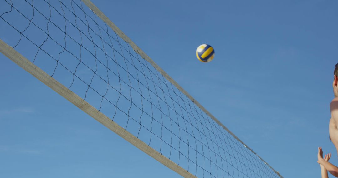 Exciting Beach Volleyball Game Under Clear Blue Sky - Free Images, Stock Photos and Pictures on Pikwizard.com