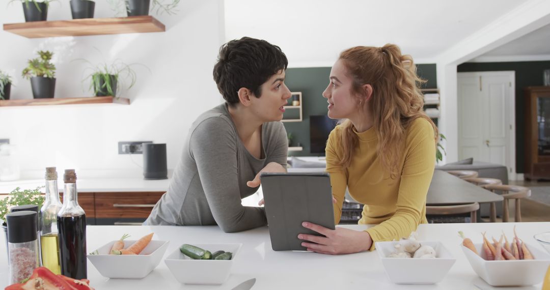 Two Women Using Tablet in Modern Kitchen - Free Images, Stock Photos and Pictures on Pikwizard.com