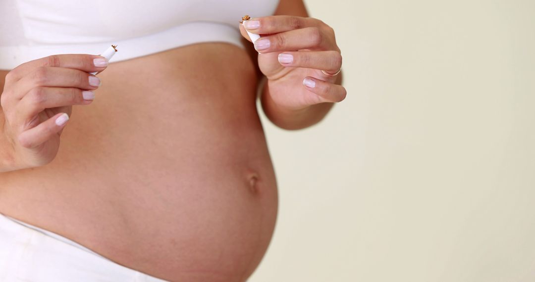 Pregnant Woman Breaking Cigarette for Healthy Lifestyle - Free Images, Stock Photos and Pictures on Pikwizard.com