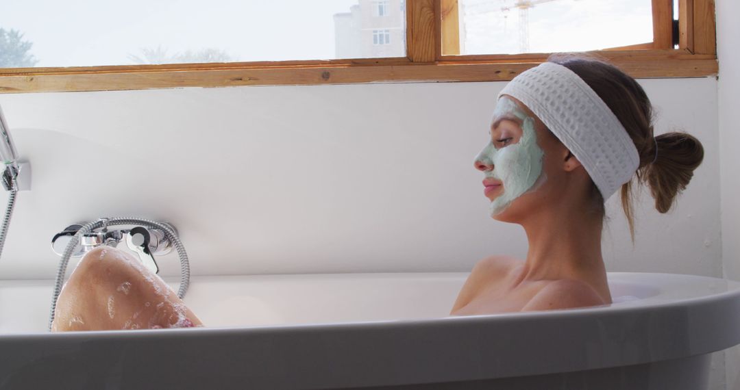 Woman Enjoying Bath with Facial Mask in Bright Bathroom - Free Images, Stock Photos and Pictures on Pikwizard.com