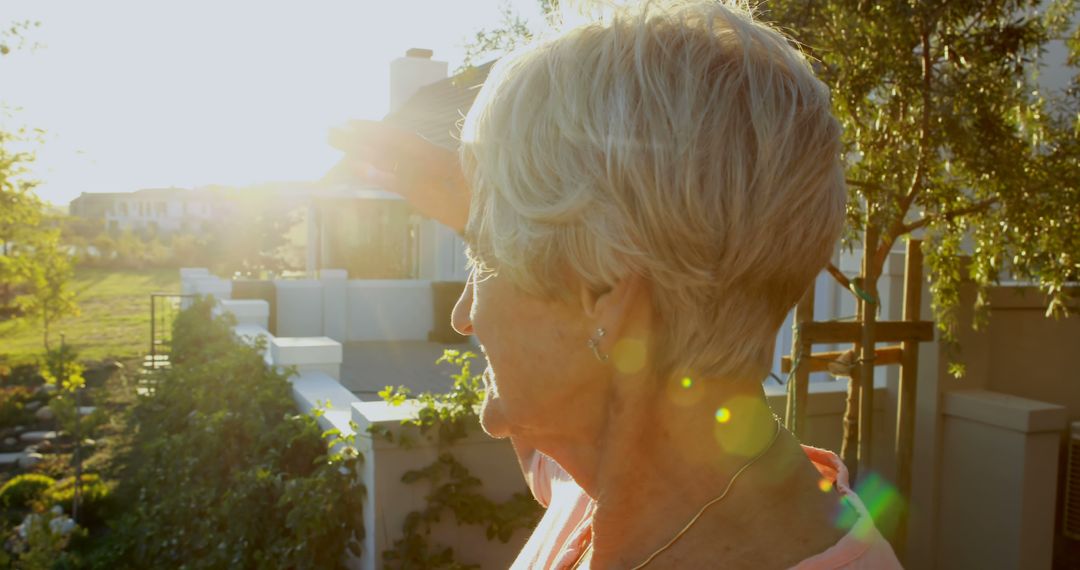 Senior Woman Appreciating Sunset in Outdoor Garden with Trees - Free Images, Stock Photos and Pictures on Pikwizard.com