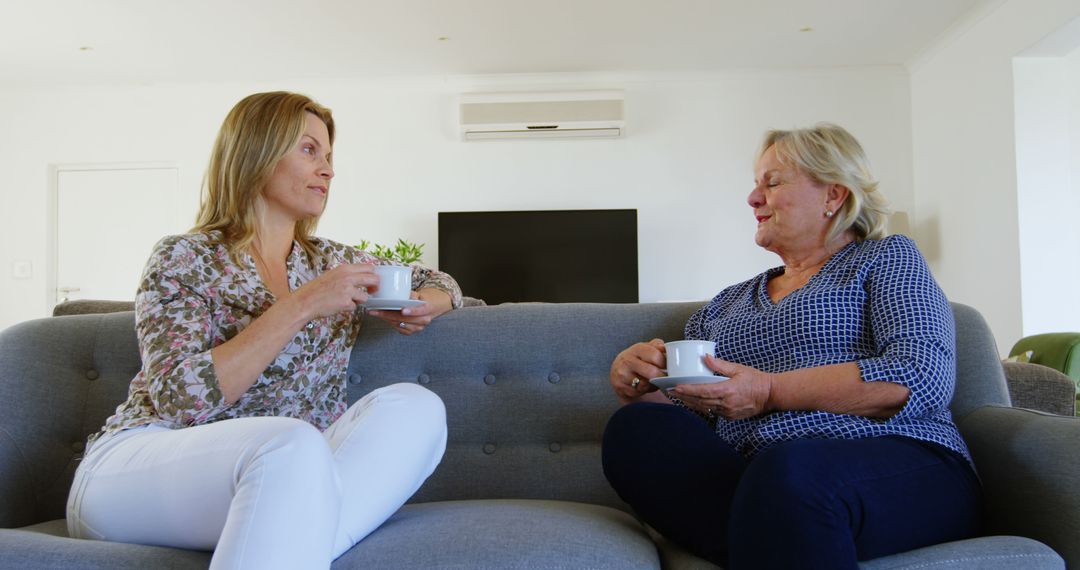 Relaxed Conversation Between Middle-Aged and Senior Women Sitting on Sofa with Coffee - Free Images, Stock Photos and Pictures on Pikwizard.com