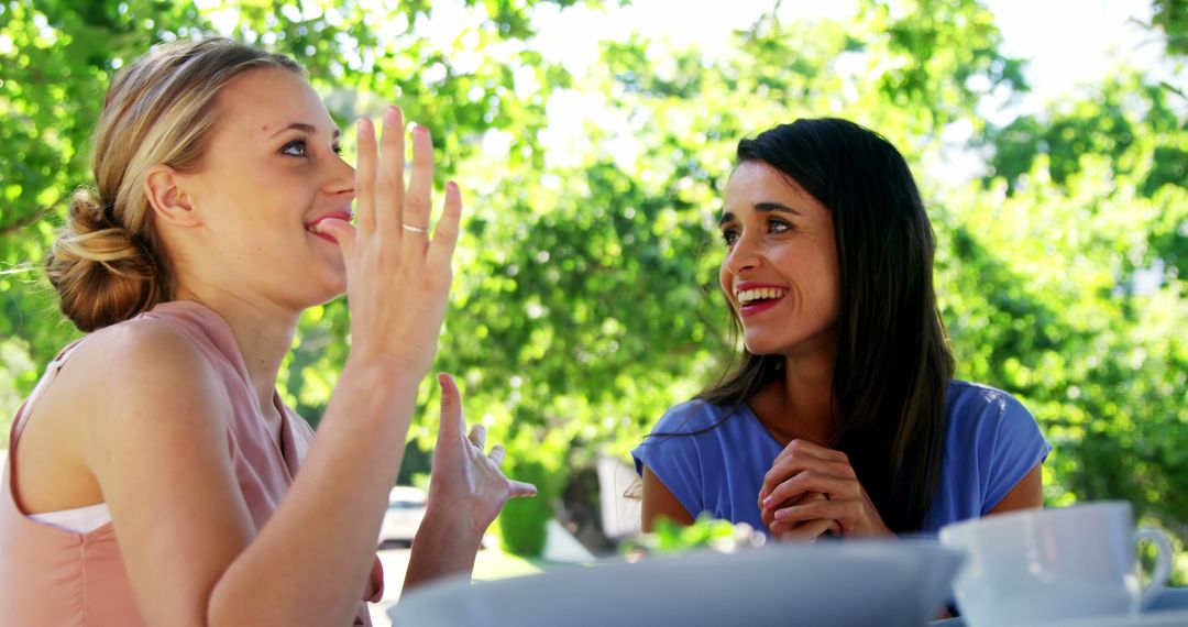 Two Women Laughing and Enjoying Conversation Outdoors - Free Images, Stock Photos and Pictures on Pikwizard.com