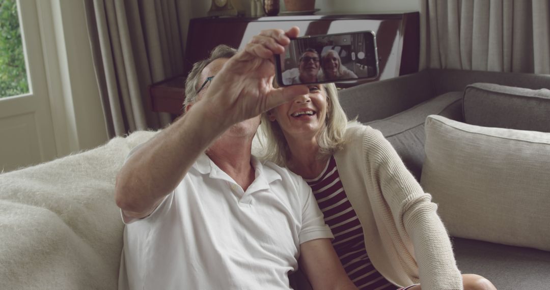 Happy Senior Couple Taking a Selfie on Couch at Home - Free Images, Stock Photos and Pictures on Pikwizard.com