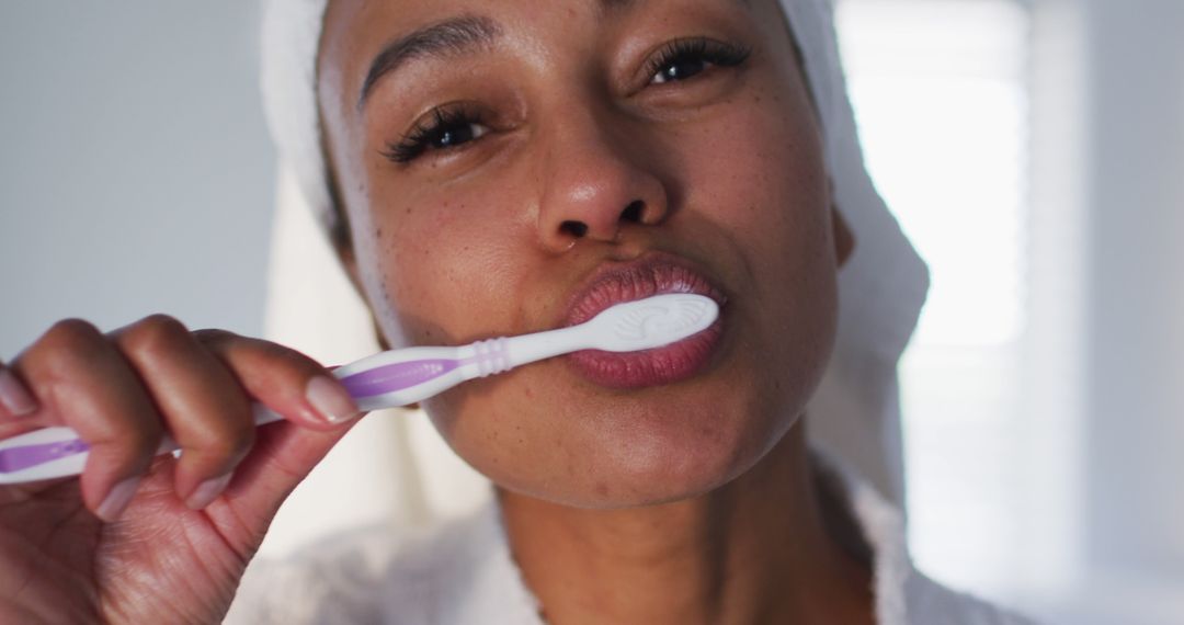 Woman Brushing Teeth at Home with Towel on Head - Free Images, Stock Photos and Pictures on Pikwizard.com