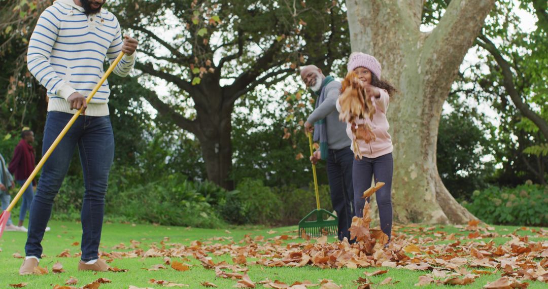 Family Having Fun Raking Leaves in Autumn Park - Free Images, Stock Photos and Pictures on Pikwizard.com