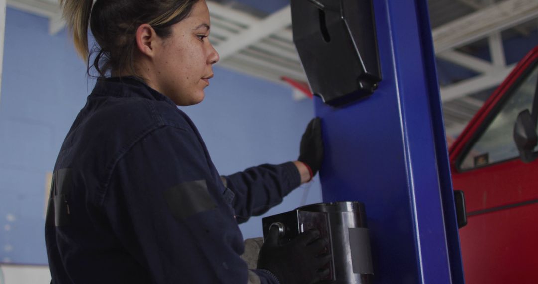 Female Mechanic Examining Automotive Equipment in a Workshop - Free Images, Stock Photos and Pictures on Pikwizard.com