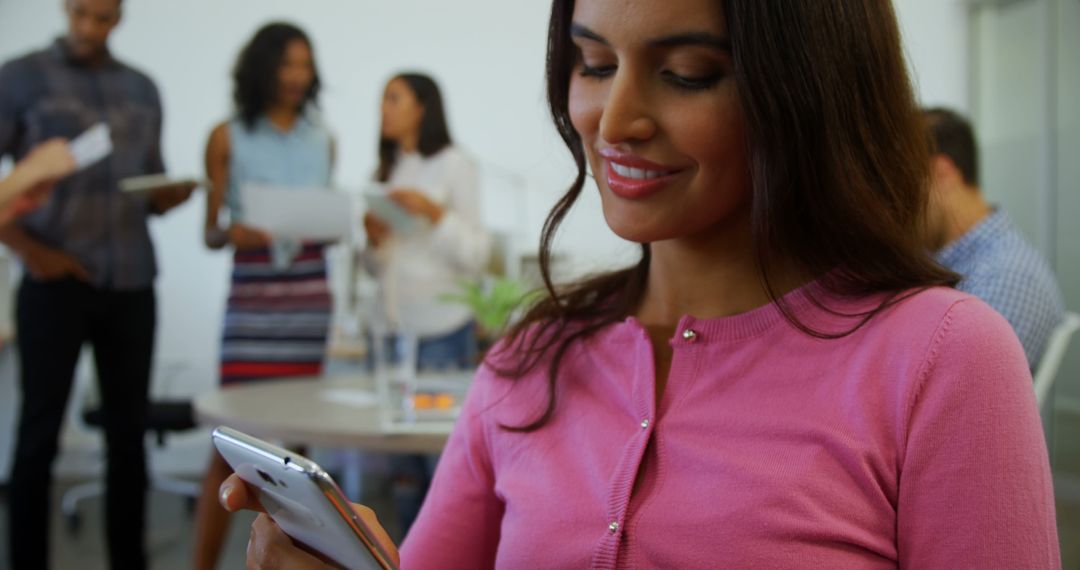 Smiling Woman Checking Smartphone in Modern Office Collaborative Environment