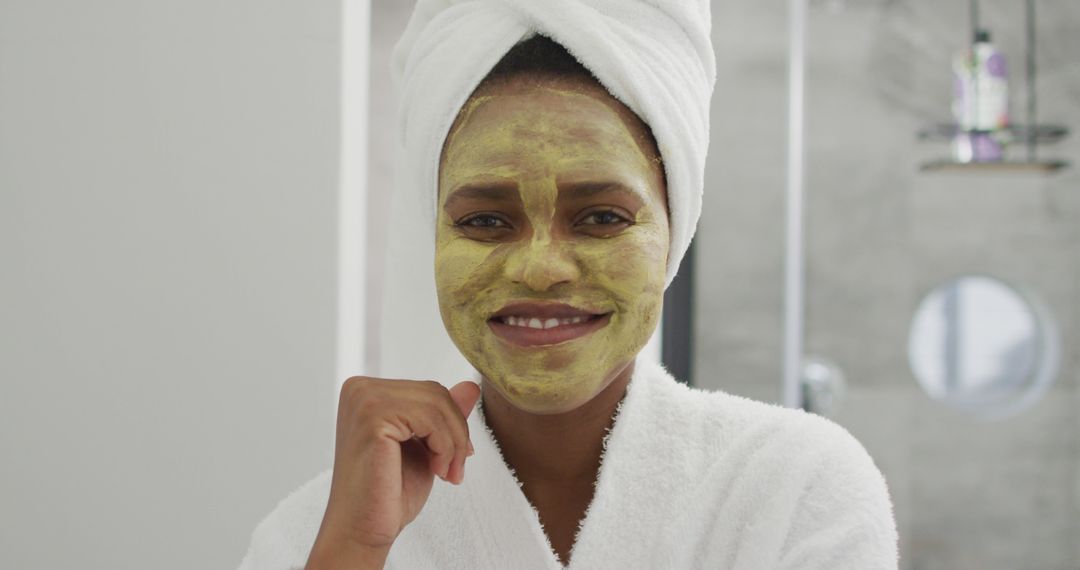 Portrait of happy african american woman with beauty mask on face, smiling in bathroom - Free Images, Stock Photos and Pictures on Pikwizard.com