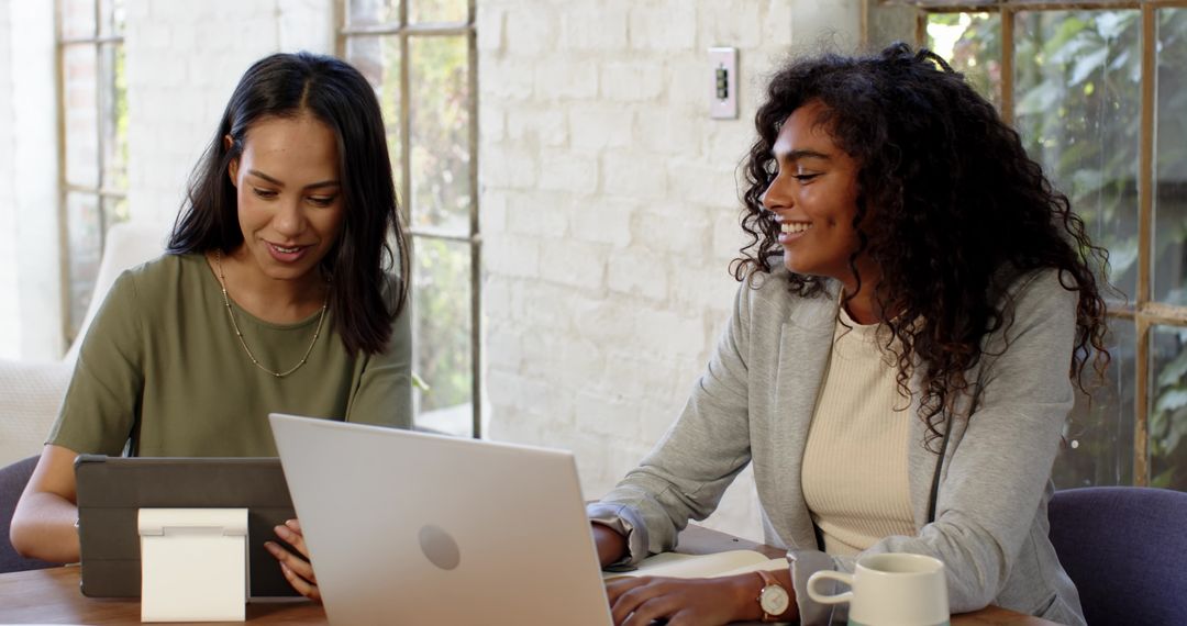Diverse Coworkers Collaborating on Tablet and Laptop