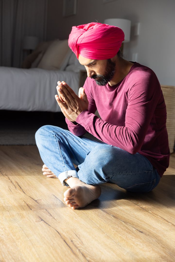 Man Wearing Red Turban Deep in Spiritual Meditation at Home