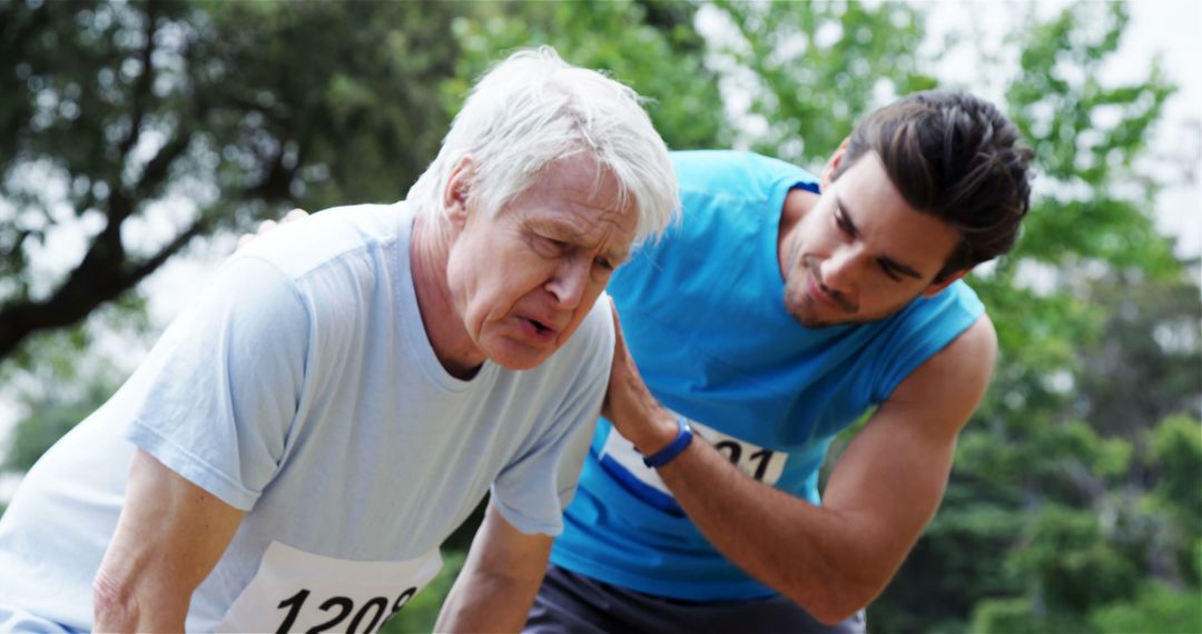 Younger Man Assisting Elderly Runner in Distress During Race - Free Images, Stock Photos and Pictures on Pikwizard.com