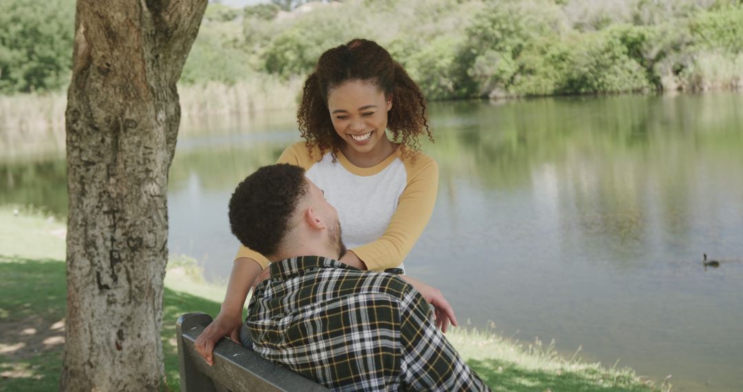 Smiling Couple Relaxing on Park Bench by Tranquil Lake