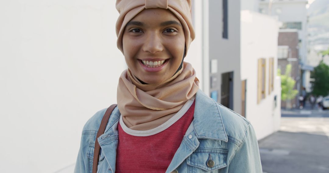 Smiling Young Woman Wearing Hijab and Denim Jacket in Urban Area - Free Images, Stock Photos and Pictures on Pikwizard.com