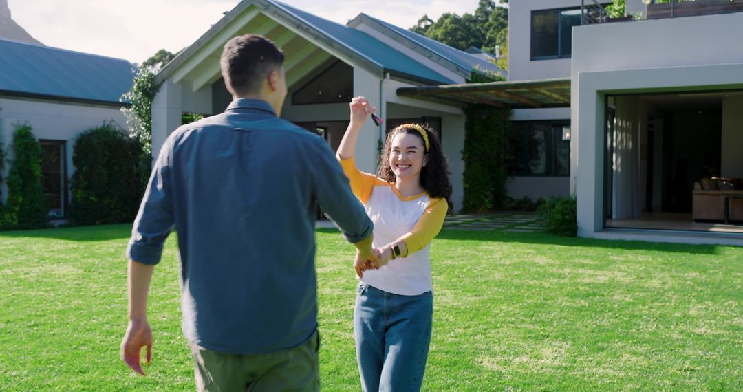 Happy Couple Exchanging Key in Front Yard of Modern Suburban Home