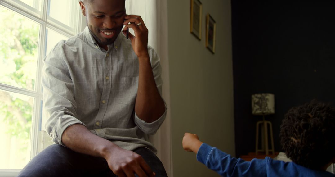 Man Having a Phone Conversation While Child Plays Nearby - Free Images, Stock Photos and Pictures on Pikwizard.com