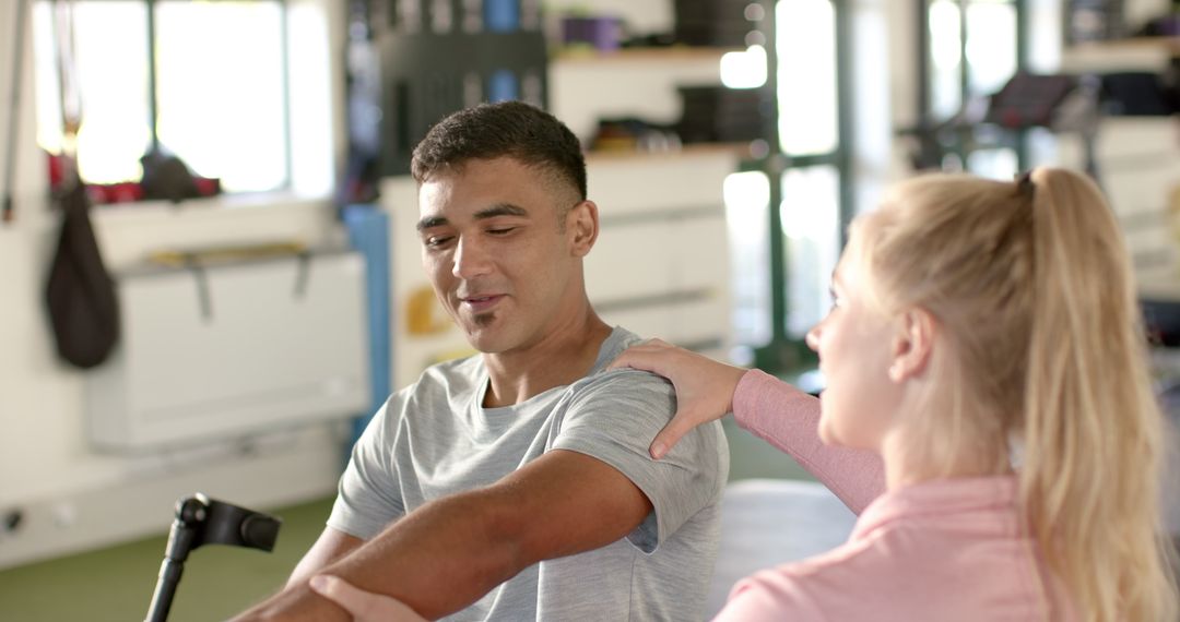 Therapist Assisting Rehabilitation for Disabled Man in Gym