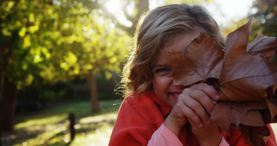 Smiling Child Playing with Autumn Leaves Outdoors - Free Images, Stock Photos and Pictures on Pikwizard.com