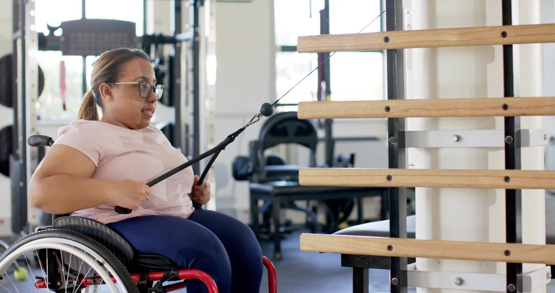 Wheelchair user training with cable row machine in gym for adaptive strength and rehab