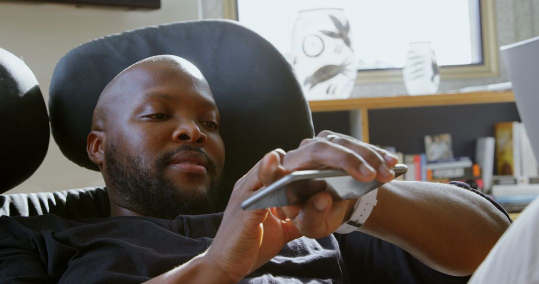 Man Relaxing on Chair with Smartphone in Cozy Home Interior