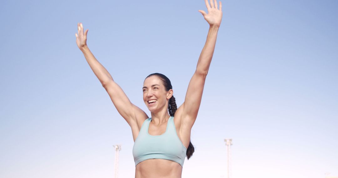 Fit Woman Celebrating Victory with Raised Arms Outdoors - Free Images, Stock Photos and Pictures on Pikwizard.com