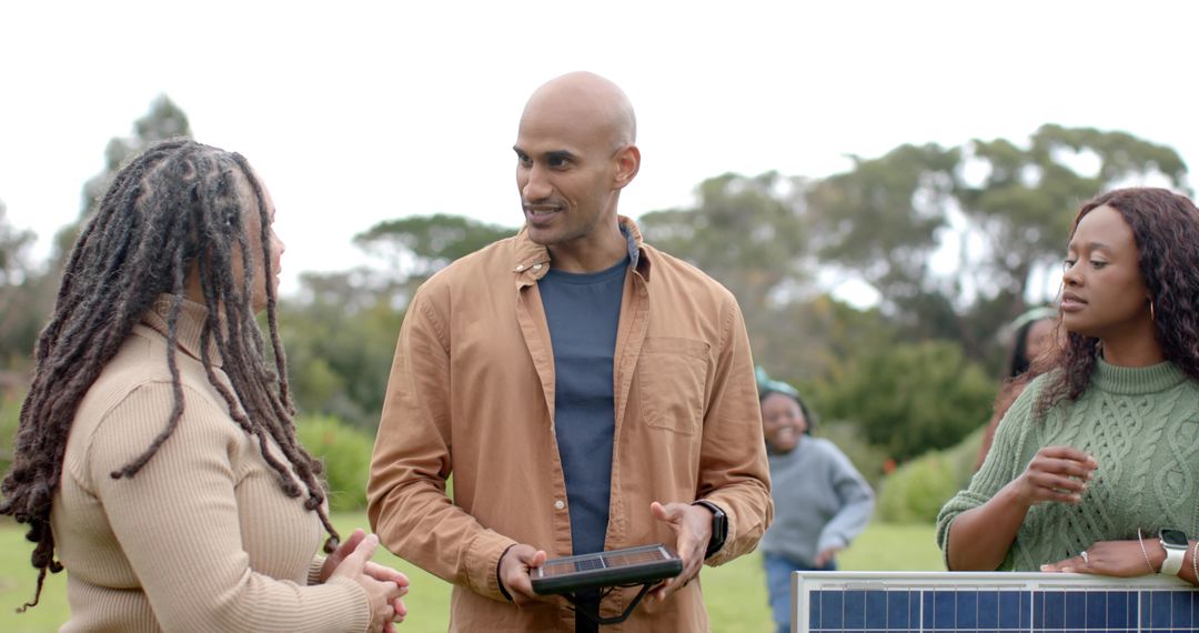 Community workshop demonstrating portable solar panel setup with diverse group outdoors