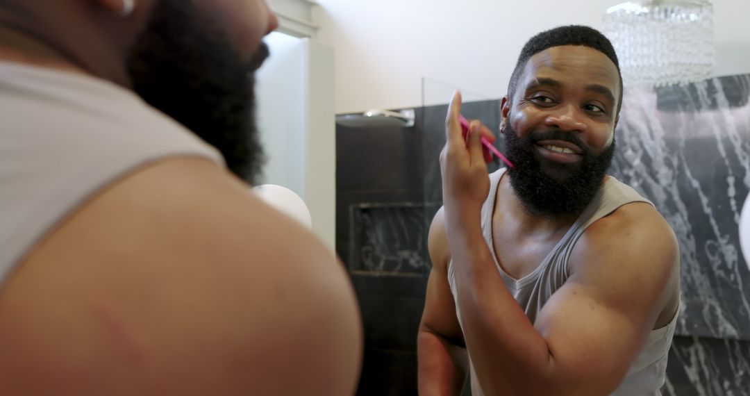 Man Shaving Beard with Razor in Modern Bathroom Vanity