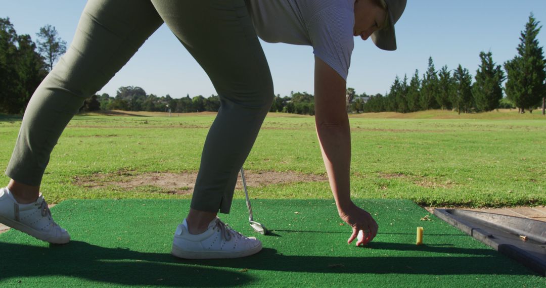 Golfer Placing Tee on Driving Range - Free Images, Stock Photos and Pictures on Pikwizard.com