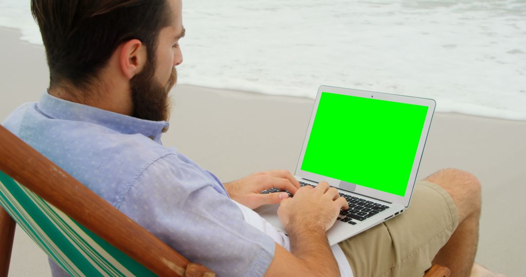 Man Working with Laptop While Relaxing on Beach