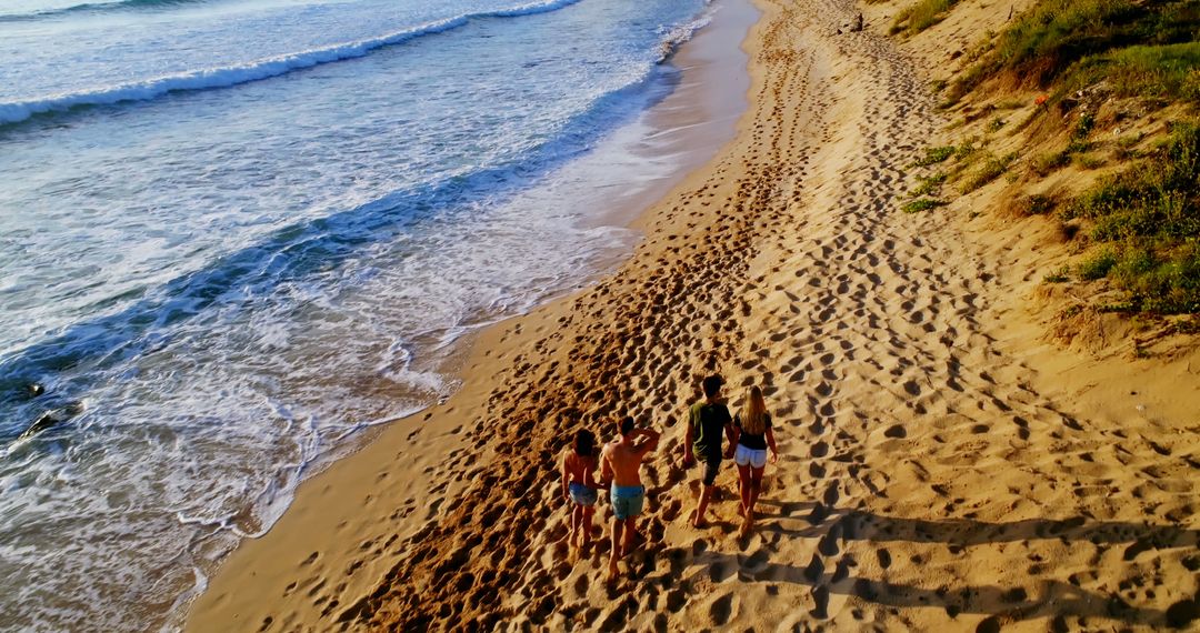 Family Walking Along Sandy Beach in Coastal Sunset - Free Images, Stock Photos and Pictures on Pikwizard.com