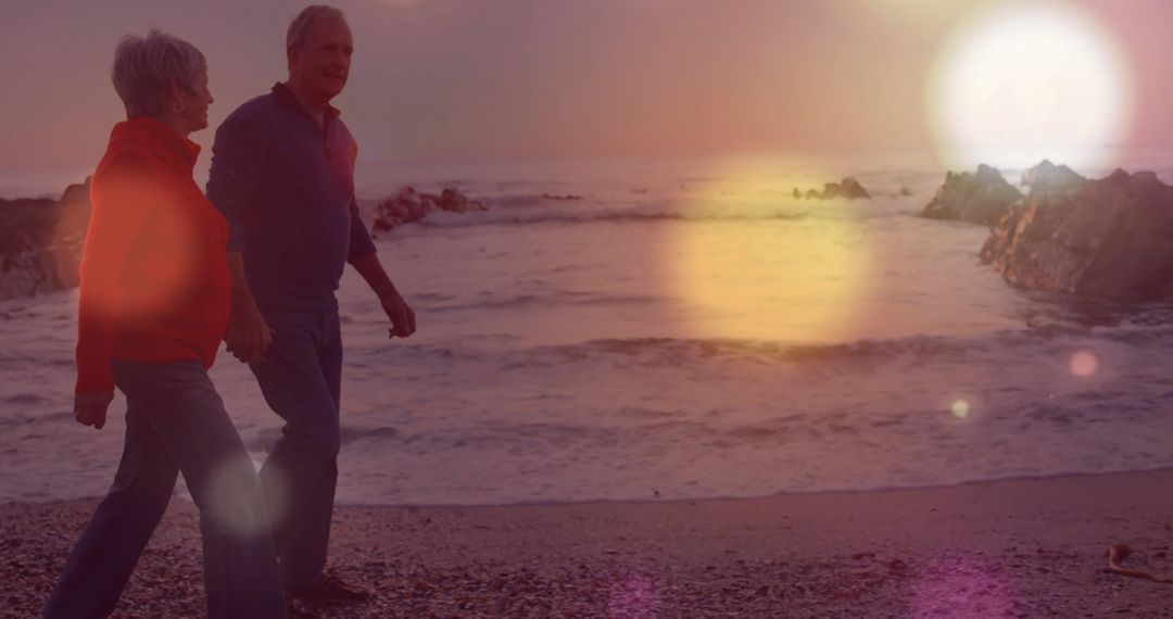Senior Couple Enjoying Romantic Walk Along Sunset Beach