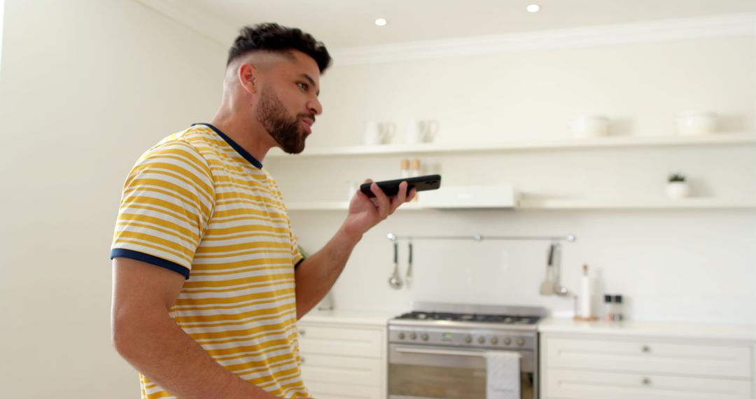 Modern Communication: Man Using Smartphone Voice Funktionen in Kitchen
